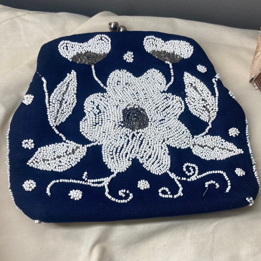 It’s a dark blue handbag with designed flowers on it,